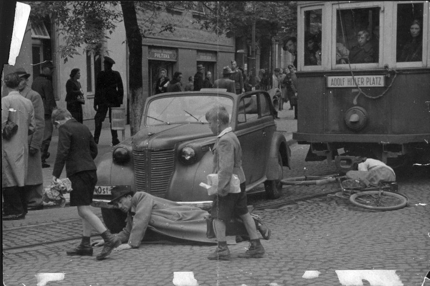 Wypadek z udziałem tramwaju typu SW1, samochodu osobowego, rowerzysty i pieszego. Fotografia pozowana. Na tramwaju widać tabliczkę Adolf Hitler Platz. 