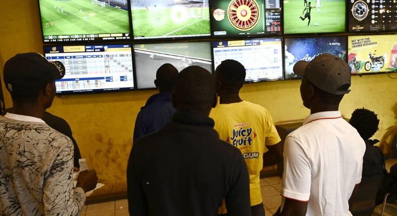 Sports enthusiasts watch different games on screens while betting at a sports betting shop in July 15, 2019 in Nairobi. - (Photo by SIMON MAINA/AFP via Getty Images)