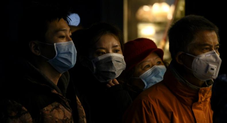 People wearing protective facemasks queue for food in Shanghai