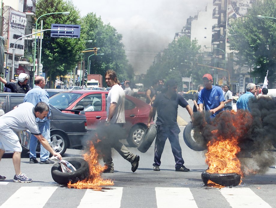 Argentine demonstrators place tires to block a main avenue to protest unpopular new banking curbs, soaring unemployment, and economic austerity measures in Buenos Aires on December 14, 2001.