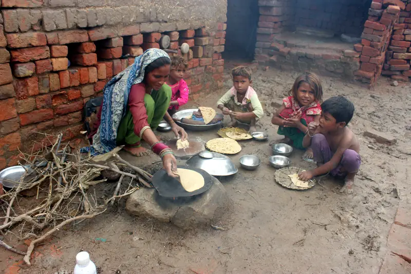 Kobieta dotknięta powodzią w Pakistanie. Przygotowuje posiłek dla siebie i swoich dzieci przy obozie tymczasowym w Tondo Jam, mieście w prowincji Sindh. / Jan Ali Laghari, Getty Images