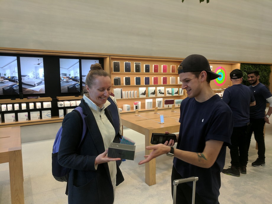 A customer being handed over her new iPhone 8. She said she "didn't need" the iPhone X.
