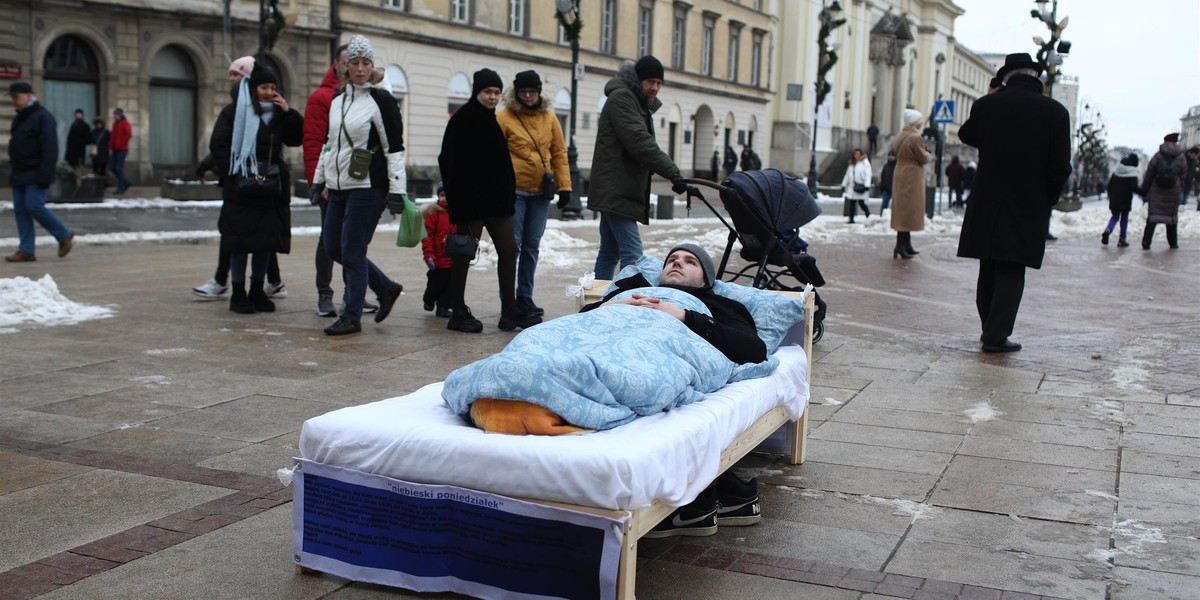 Jakub leży w łóżku pod gołym niebem w centrum Warszawy