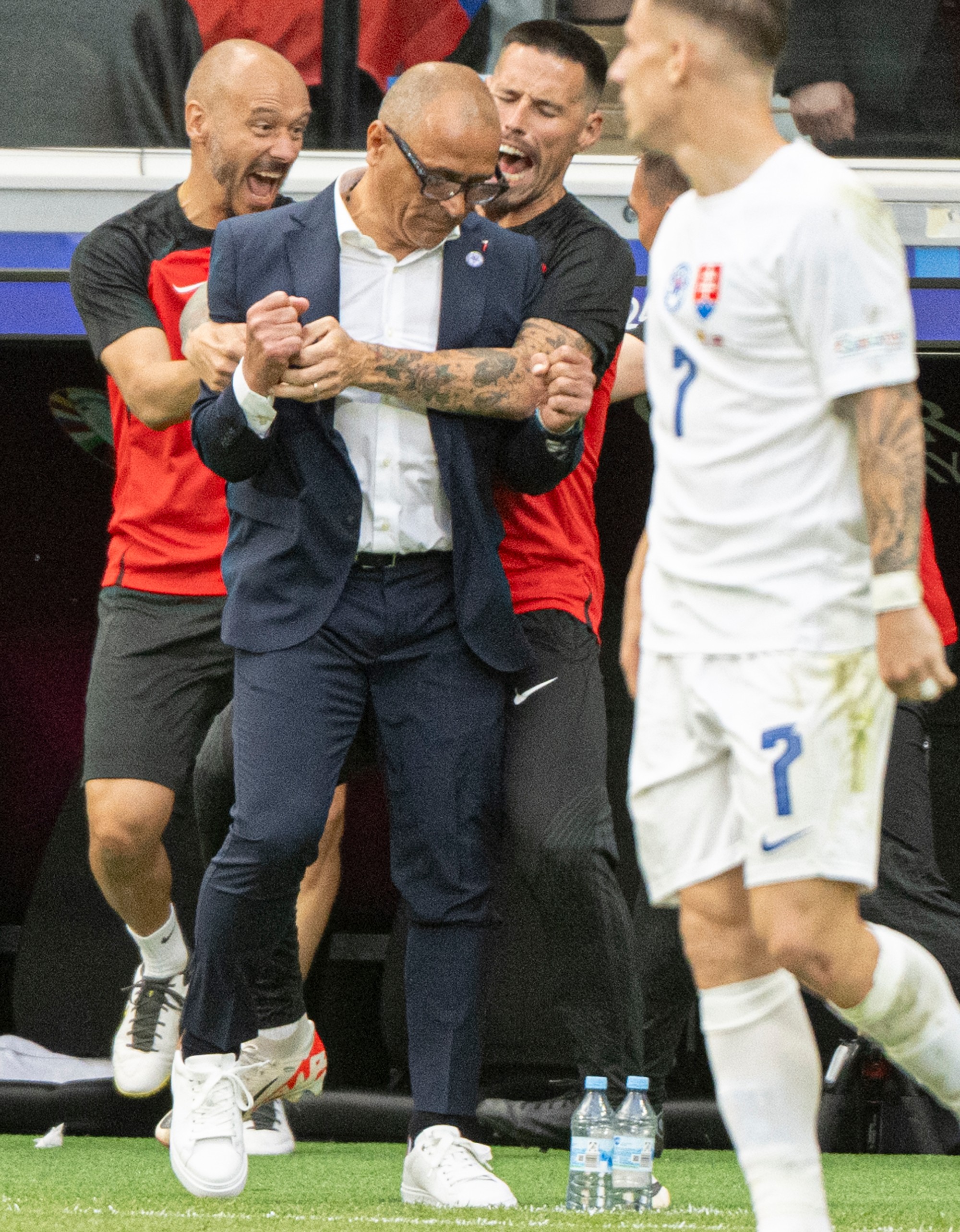 Tréner slovenskej futbalovej reprezentácie Francesco Calzona (uprostred), manažér tímu a asistent trénera Marek Hamšík (druhý vpravo) a hráč Tomáš Suslov sa radujú.