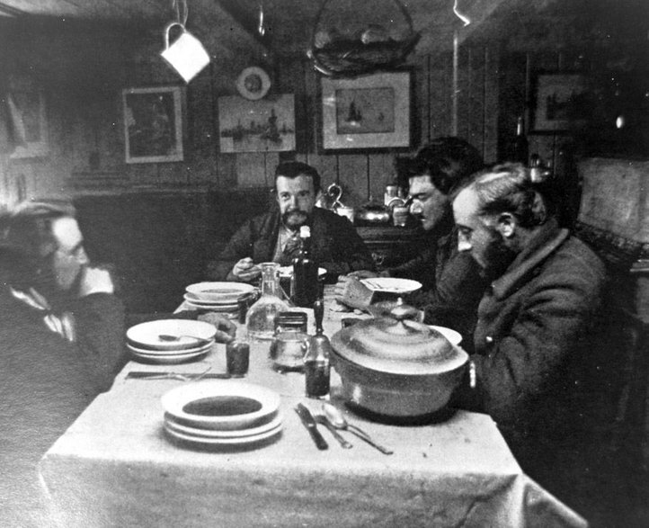 Kolacja Bożonarodzeniowa na statku „Belgica” (25 grudnia 1898 roku) Od lewej - Henryk Arctowski, Georges Lecointe, Emil Racoviţă, Adrien de Gerlache (fot. domena publiczna)