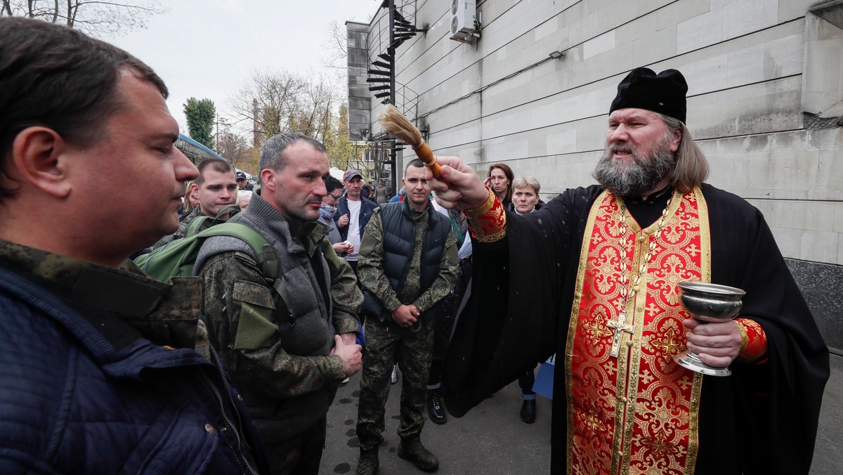 Prawosławny duchowny błogosławi mężczyzn zmobilizowanych na wojnę w Ukrainie