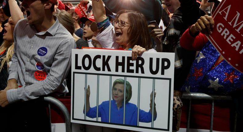 A Trump supporter holds a sign depicting former Secretary of State Hillary Clinton behind bars during a November 2016 rally in Leesburg, Va.