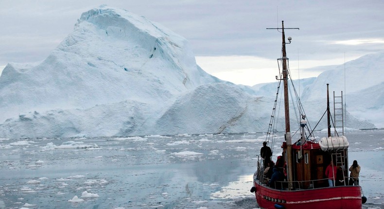 A boat steers slowly through floating ice, and around icebergs, all shed from the Greenland ice sheet, outside Ilulissat, Greenland.AP/Brennan Linsley