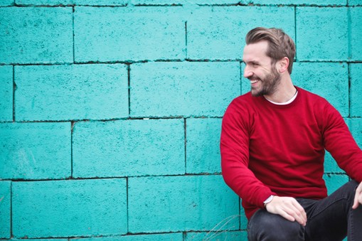 man-wearing-red-sweatshirt-and-black-pants-leaning-on-the-845434