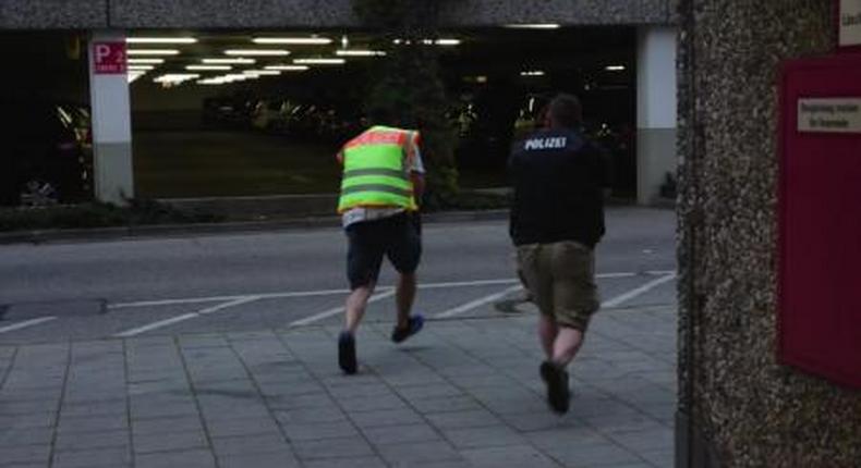 A screen grab taken from video footage shows plain clothes police officers running towards car park of the Olympia shopping mall during shooting rampage in Munich, Germany July 22, 2016. 