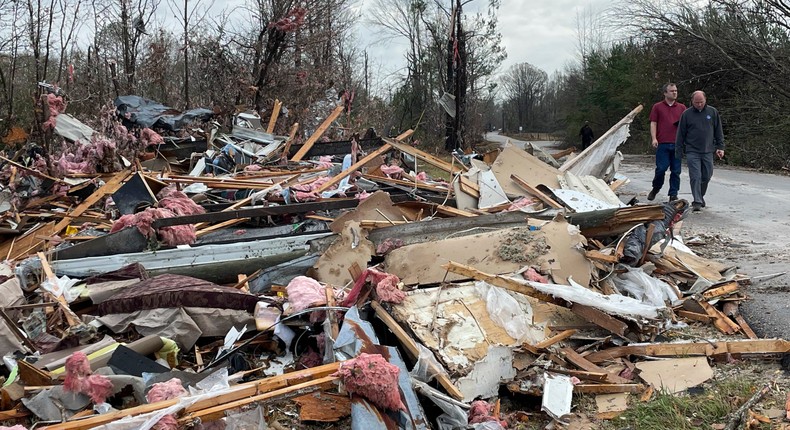 People walk through an area of destoryed structures in Flatwood, Ala. on Wednesday, Nov. 30, 2022.AP Photo/Butch Dill