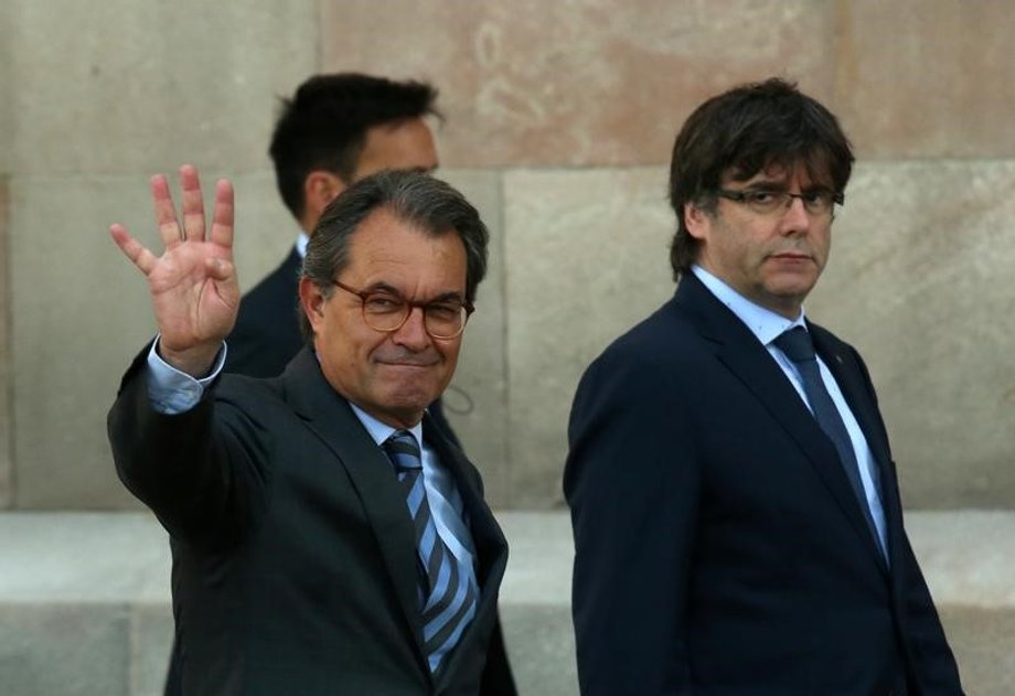 Catalonia's regional President Carles Puigdemont and former regional President Artur Mas salute the crowd in Barcelona