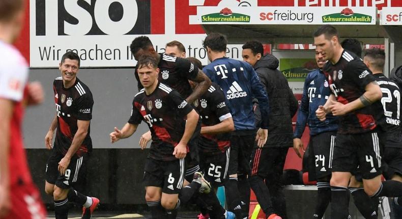 Bayern Munich striker Robert Lewandowski (L) celebrates scoring his 40th Bundesliga goal this season to equal Gerd Mueller's 49-year-old record Creator: Thomas KIENZLE