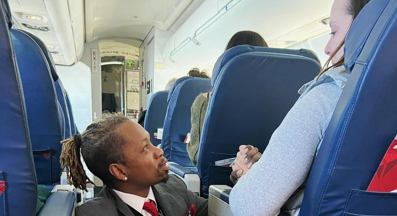 Delta flight attendant Floyd Dean-Shannon consoles a passenger on a flight from Charlotte, North Carolina, to NYC on January, 14, 2023.Molly Simonson Lee