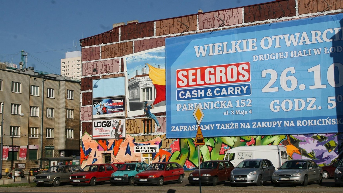 "Polska The Times": Jeszcze kilka dni temu na ścianie kamienicy przy ulicy Żwirki 8 pięknie prezentowały się dwie postacie z flagą Łodzi i pocztówką. Teraz zasłonięto je wielką reklamą sklepu.