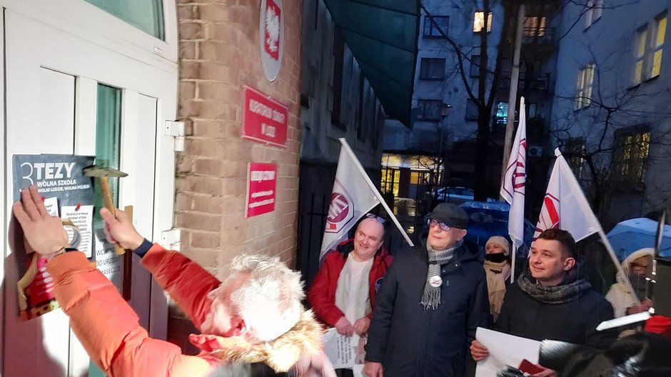 Protest w obronie edukacji w Łodzi. Protestujący przybijają tezy do drzwi kuratorium