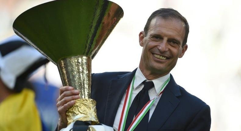 Juventus' coach Massimiliano Allegri poses with the trophy after winning the scudetto at the Juventus Stadium in Turin on May 21, 2017