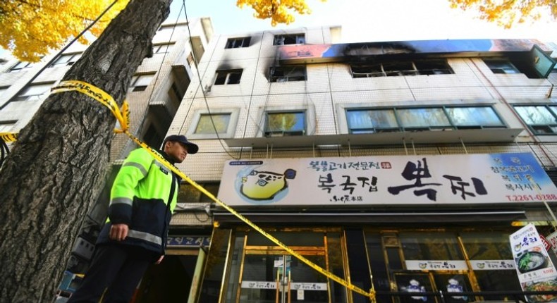 A South Korean policeman stands guard outside the scene after a fire that killed at least seven people in Seoul