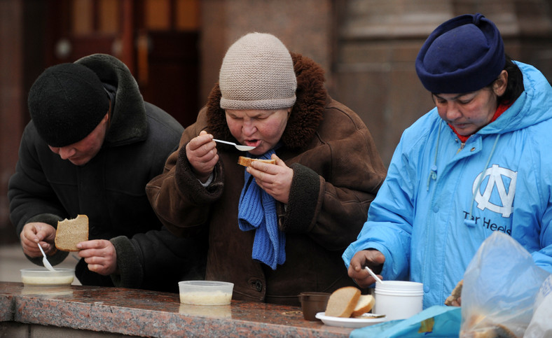 Bezdomni w Rosji jedzący darmowy posiłek, 2009 r.