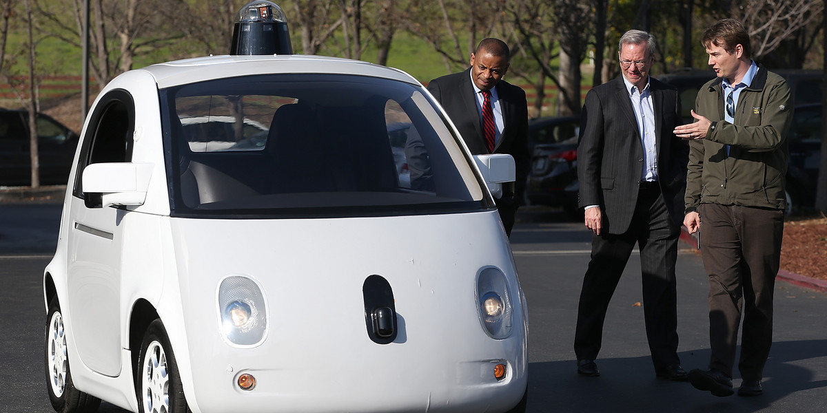 Rok 2015: Chris Urmson (pierwszy z prawej) przedstawia samojeżdżący samochód Google'a Ericowi Schmidtowi (obecnie prezesowi zarządu Alphabet Inc., drugi z prawej) i Anthony'emu Foxxowi, sekretarzowi transportu USA