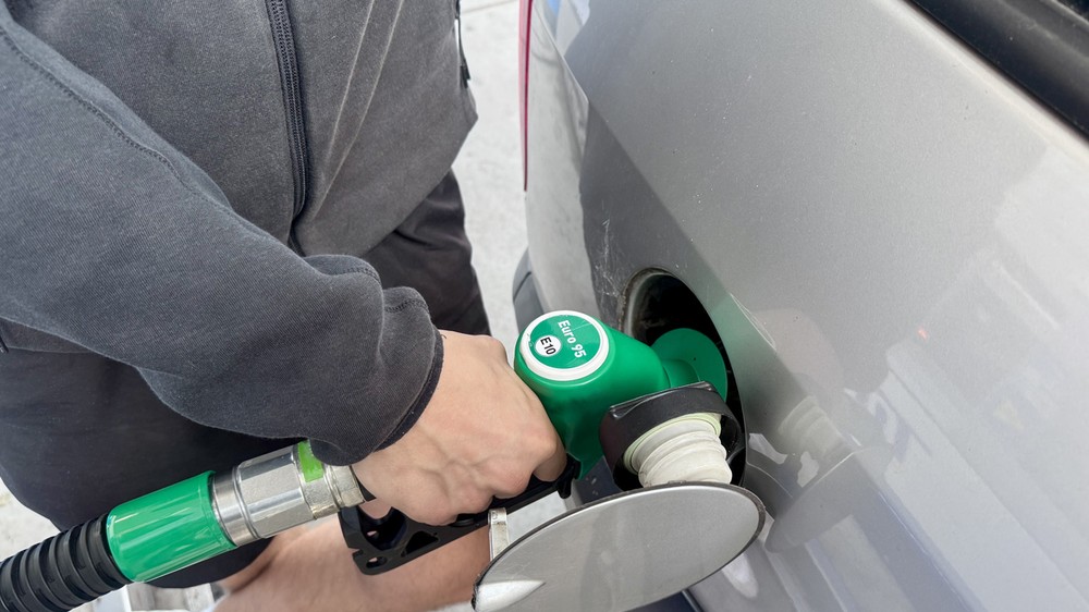 Detailný záber na palivovú pištoľ a displej čerpacej stanice s označením E10.