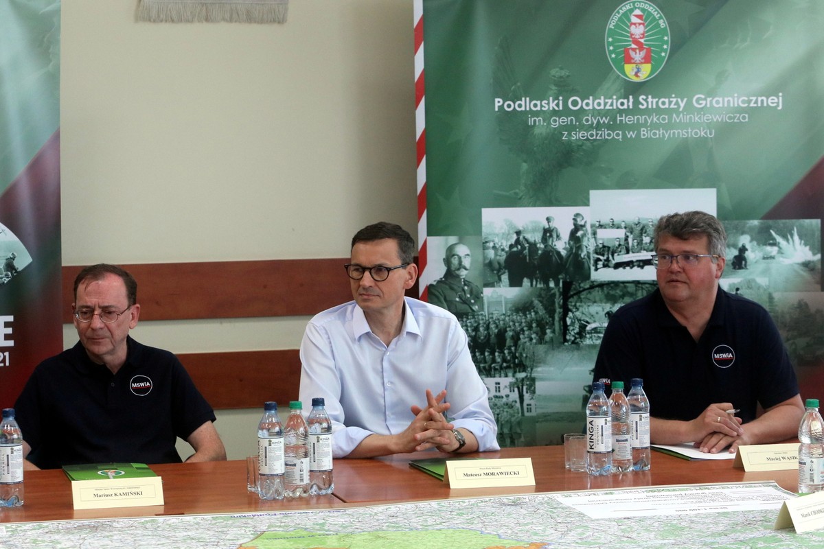 Premier Mateusz Morawiecki (C), minister spraw wewnętrznych i administracji Mariusz Kamiński (L) oraz wiceszef MSWiA Maciej Wąsik (P) podczas odprawy w placówce Straży Granicznej w Kuźnicy