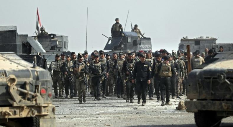 Iraqi Special Forces parade with Staff Lieutenant General Abdul Ghani Al-Asadi, commander of the Counter-Terrorism Service in a recently recaptured district of southeast Mosul, on November 27, 2016
