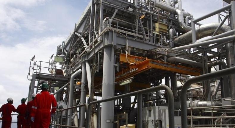 Oil workers walk through pipe installations on a tanker at Bonga off-shore oil field outside Lagos, October 30, 2007. 