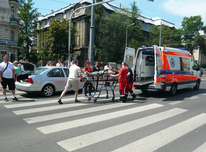 ratownicy wkładają rannego pacjenta do karetki pogotowia