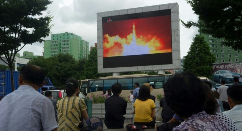 People watch as coverage of an ICBM missile test is displayed on a screen in a public square in Pyongyang on July 29, 2017