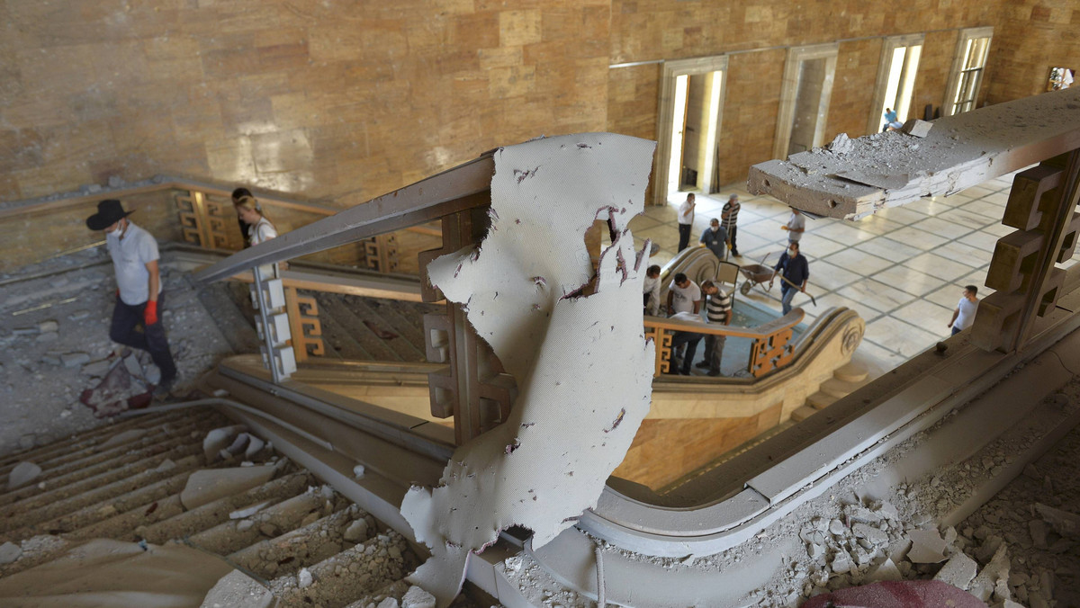 People walk inside the damaged parliament building in Ankara