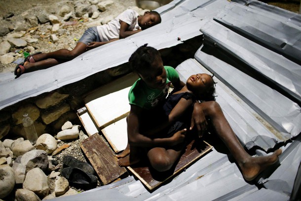 Children sleep over metal sheets in a partially destroyed school used as a shelter after Hurricane M