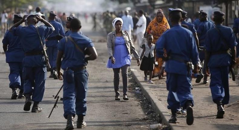 A woman passes by policemen during a protest against Burundi President Pierre Nkurunziza and his bid for a third term in Bujumbura, Burundi, June 2, 2015. REUTERS/Goran Tomasevic
