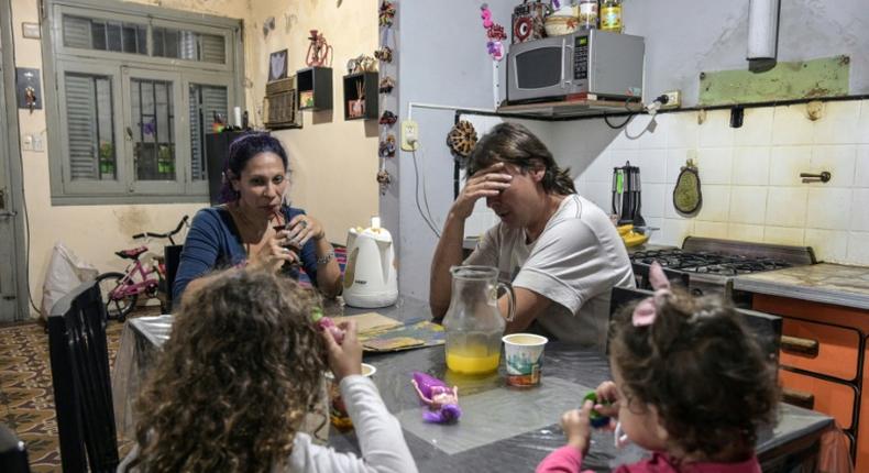 Between the two of them, Argentine couple carpenter Ariel Fernandez (2nd R) and his wife, teacher Natalia Morales (L), earn the equivalent of around $1,200 a month as more and more people in the country fall below the poverty line