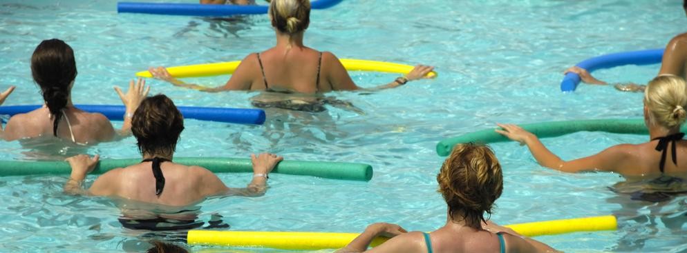 <strong>Aqua aerobik</strong>
<br></br>
Regularni bywalcy zajęć fitness w okresie upalnych tygodni mogą - zamiast czasem gorących sal klubowych - zamienić je na pływalnie z chłodzącą wodą. Zajęcia w wodzie z ciężarkami, makaronami i deskami także pozwalają utrzymać kondycję i sylwetkę. Dla lubiących intensywny wysiłek prowadzone są m.in. zajęcia na specjalnych rowerach zanurzonych w wodzie. 
<br></br>
Aqua aerobik nie wymaga umiejętności pływania i - dzięki odciążeniu stawów oraz wyporowi wody - jest bezpieczny dla osób z nadwagą, osteoporozą czy dysfunkcjami narządu ruchu. 
<br></br>