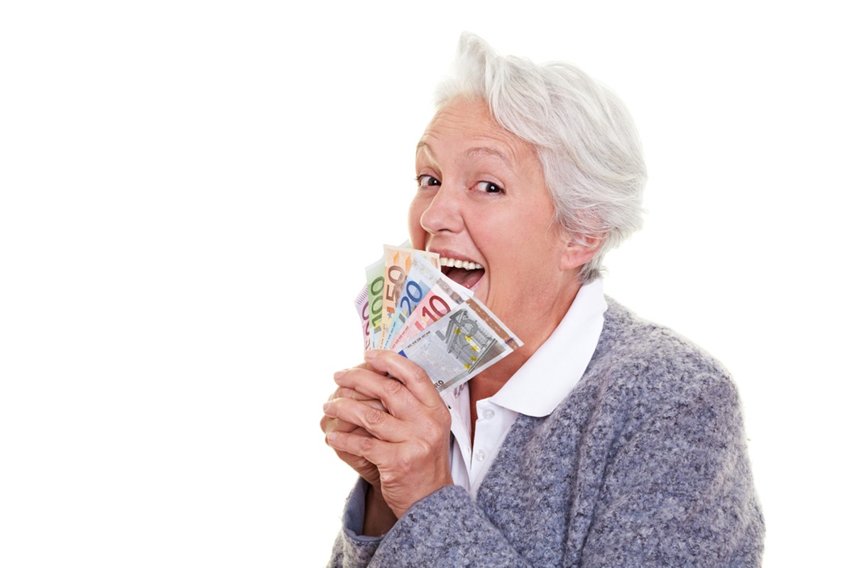Seniorak z plikiem banknotów w dłoni, mat. shutterstock