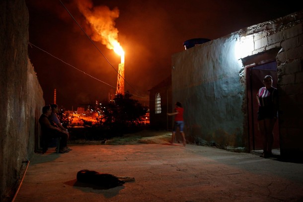 People talk outside their houses close to Cardon refinery complex which belongs to the Venezuelan st