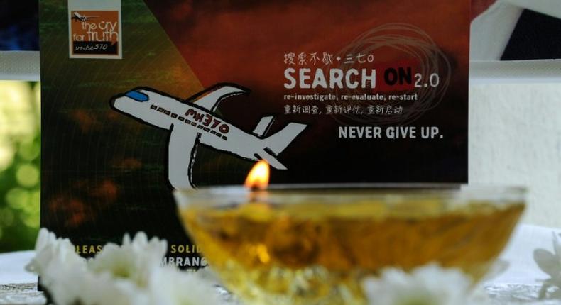 A candle burns a prayer message for passengers of missing Malaysia Airlines flight MH370 in Petaling Jaya on March 8, 2016