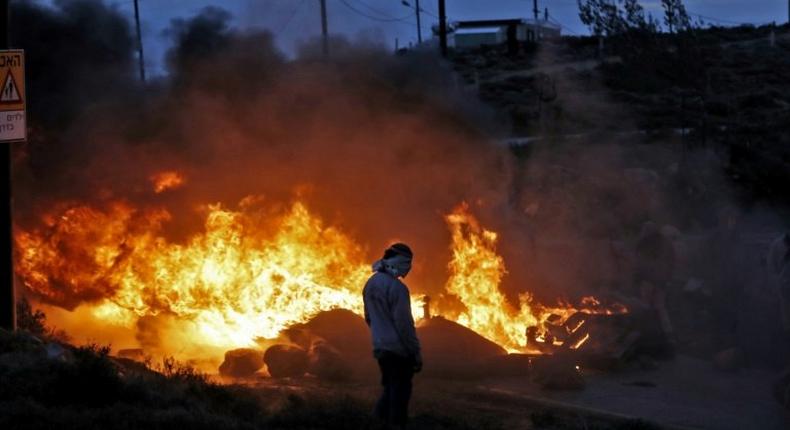 Jewish settlers set tyres ablaze at the Amona outpost, northeast of Ramallah, on February 1, 2017