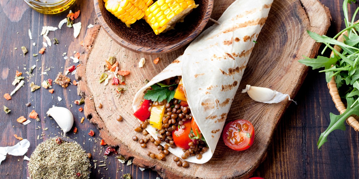 Vegan tortilla wrap, roll with grilled vegetabes, lentil, corn cob.