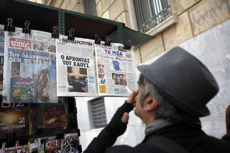 Grecja. Przechodzień z papierosem czyta tytuły dzienników w kiosku ulicznym w Atenach, 2 listopada 2011