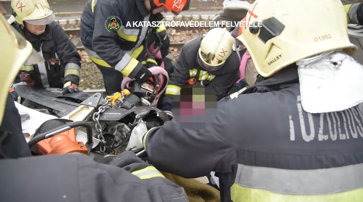 A katasztrófavédelem munkatársai együttes erővel próbálták kiszedni a 47 éves nőt az összetört autóból. / Fotó: Screenshot / BM Országos Katasztrófavédelmi Főigazgatóság