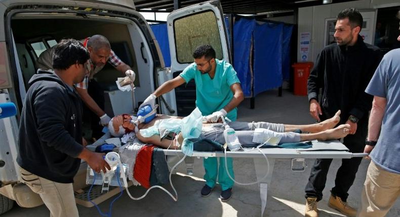 A civilian injured during the ongoing fighting between Iraq government forces and Islamic State (IS) group jihadists in Mosul is wheeled into a trauma field hospital