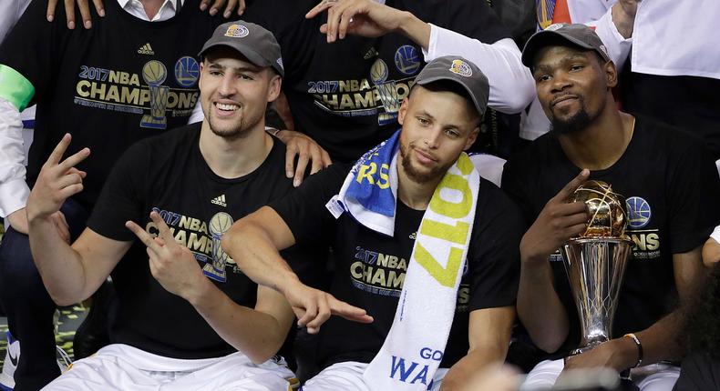 Golden State Warriors guard Klay Thompson, from left, guard Stephen Curry and forward Kevin Durant celebrate after Game 5 of basketball's NBA Finals against the Cleveland Cavaliers in Oakland, Calif., Monday, June 12, 2017. The Warriors won 129-120 to win the NBA championship.