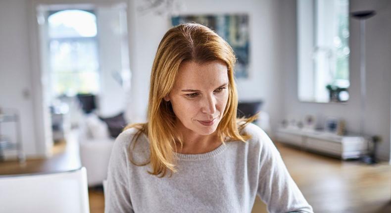 Woman working at home desk on laptop