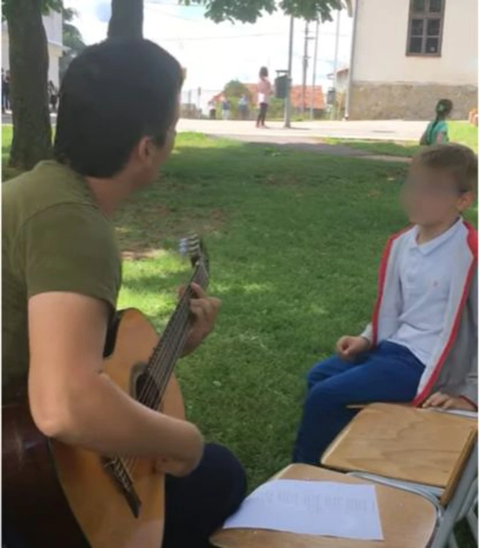 Učitelj Milovan svira gitaru svojim đacima