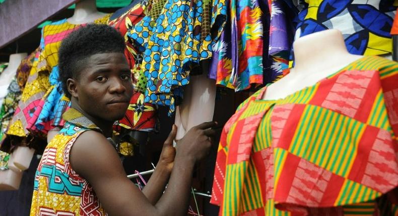 A tailor prepares clothes to sell at an African clothes shop in Monrovia