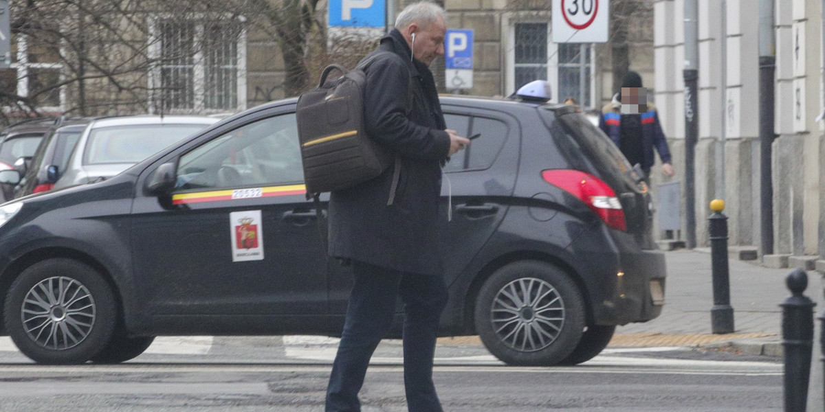 Poseł Jacek Protasiewicz na przejściu dla pieszych był zapatrzony w swój telefon. 