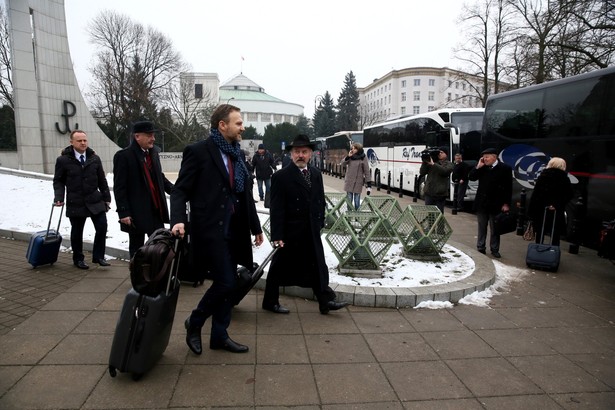 Posłowie PiS wsiadają do autokarów przed Sejmem