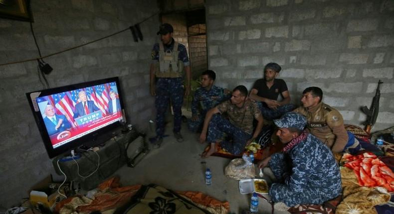 Members of the Iraqi armed forces watch Donald Trump giving a speech after he won the US presidential elections in November